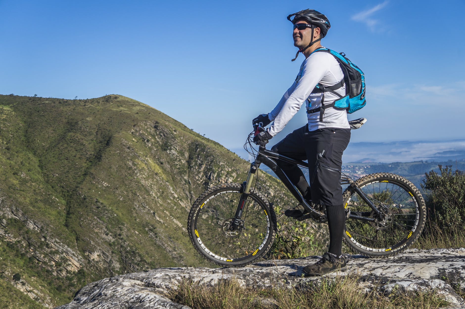 man with white shirt riding abicycle on a mountain